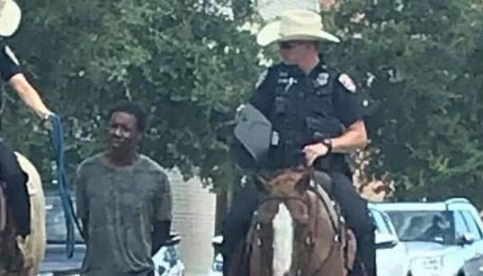 Au Texas, des policiers à cheval mènent un homme noir menotté avec une