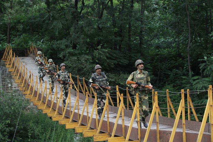 Border Security Force (BSF) soldiers patrol over a footbridge near the Line of Control.