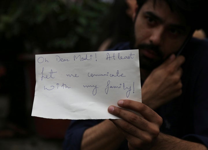 A Kashmiri, who works in Bangalore, holds a piece of paper addressing Prime Minister Narendra Modi during a protest against the government revoking Kashmir's special constitutional status in Bangalore, Aug. 5, 2019.