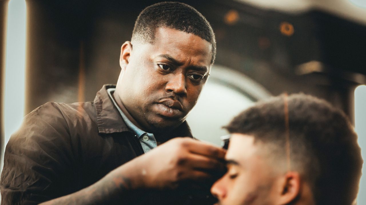 Leslie “Bud Tha Barber” Marks cuts a client's hair at Plus Midtown Barber and Beauty Salon in Atlanta.