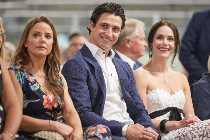 Scott Moir sits with his ice dance partner Tessa Virtue, right, and his fiancée Jackie Mascarin, left, during the ceremony for the unveiling of his Canada's Walk of Fame in Ilderton, Ont. on Aug. 7, 2019.