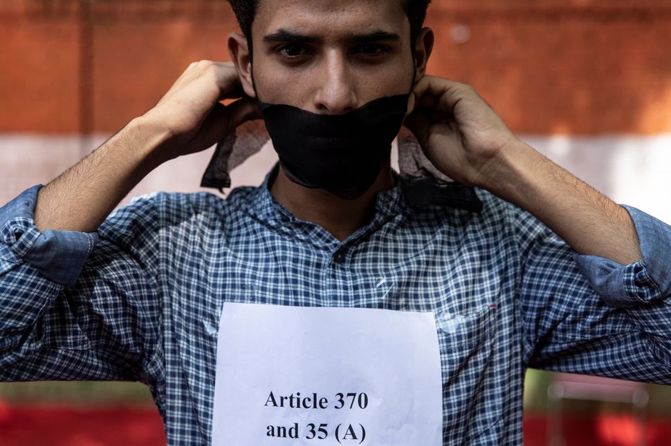 A Kashmiri man covers his mouth during a protest against the scrapping of the special constitutional status for Jammu and Kashmir by the Modi government, in New Delhi on August 9, 2019.