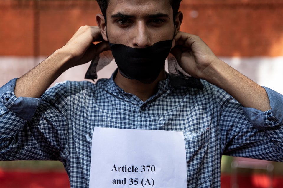 A Kashmiri man covers his mouth during a protest against the scrapping of the special constitutional...