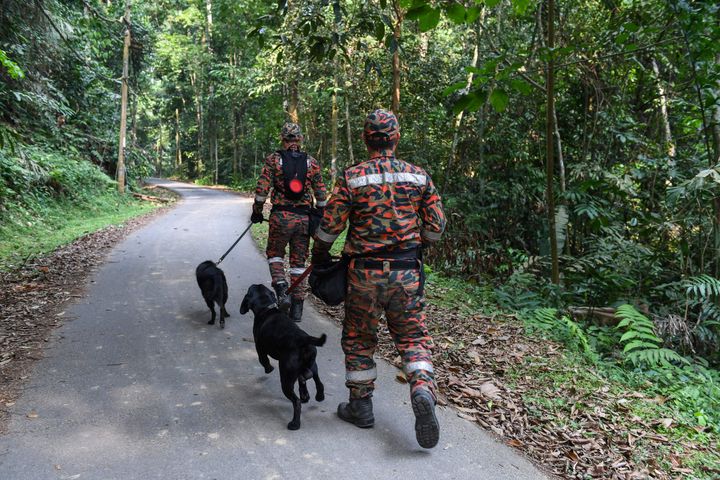 Members of a Malaysian K-9 unit taking part in a search and rescue operation for the missing 15-year-old 