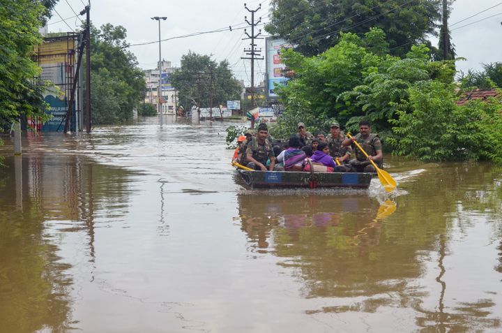 In this photograph taken on August 8, 2019, Indian Army personnel rescue people stranded in flood waters after heavy rains on the outskirts of Sangli in Maharashtra state. - Parts of Maharashtra, Karnataka and Kerala are suffering one of the worst floods in recent years after heavy monsoon rains.