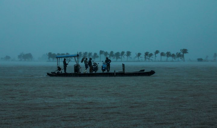 Residents are being evacuated from their home to a safer place following floods warnings, on a wooden boat at Kadamakkudi near Kochi in the Indian state of Kerala on August 10, 2019