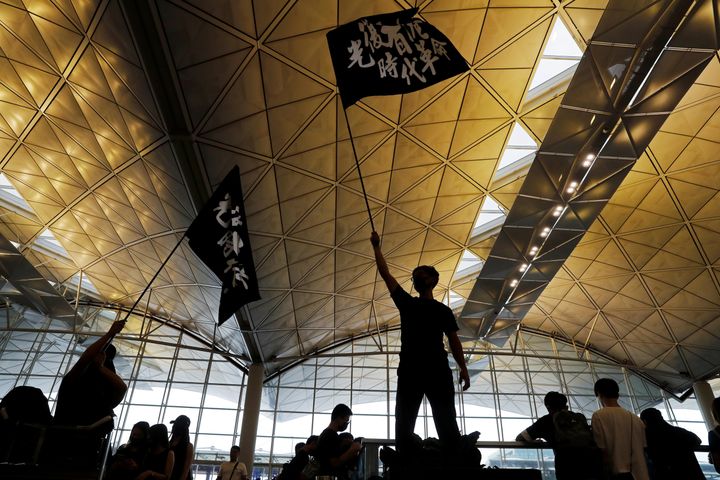 Anti-extradition bill protesters wave flags with Chinese calligraphy that reads "Liberate Hong Kong, the revolution of our times", at a mass demonstration after a woman was shot in the eye during a protest at Hong Kong International Airport, in Hong Kong, China August 12, 2019. 