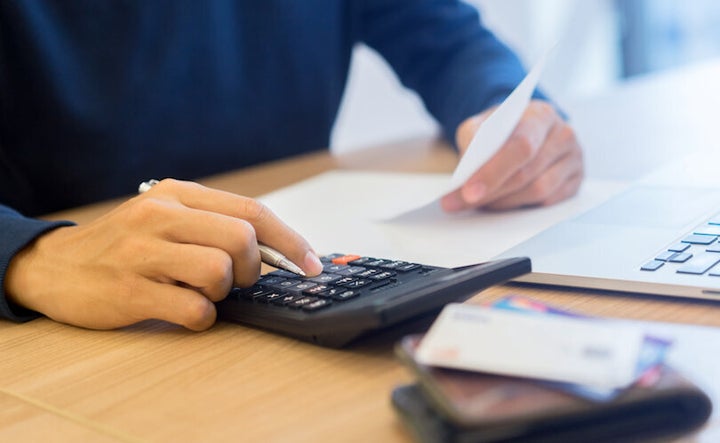 A man uses a calculator to determine the state of his finances.