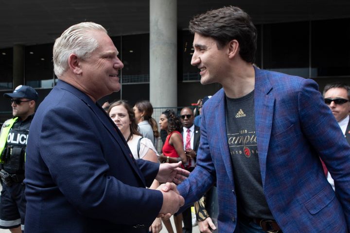 Prime Minister Justin Trudeau, right, shakes hands with Ontario Premier Doug Ford during the 2019 Toronto Raptors Championship parade in Toronto, on June 17, 2019.