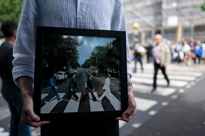 A fan holds the cover of The Beatles' "Abbey Road" outside Abbey Road Studios in London on Aug. 8, the 50th anniversary of the album's release.