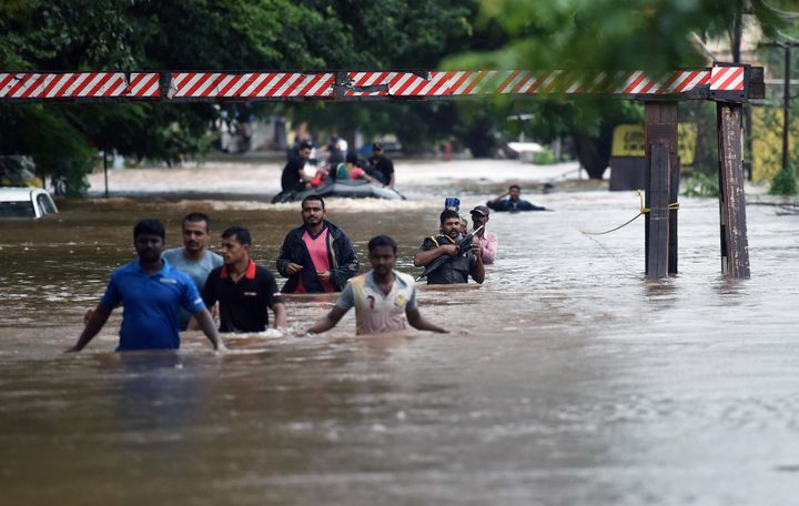 People walk through flooded streets of Sangli on 9 August 2019 in Maharashtra. 