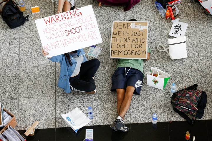 Anti-government demonstrators sit in a designated area of the arrival hall of the airport, after police and protesters clashed the previous night, in Hong Kong on Aug. 14, 2019. 