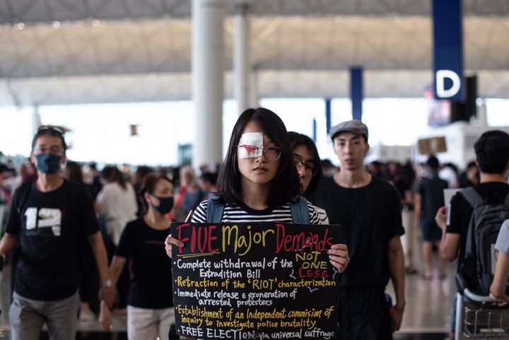 A pro-democracy protester holds a placard during another demonstration at Hong Kong's international airport on Aug. 13, 2019. 