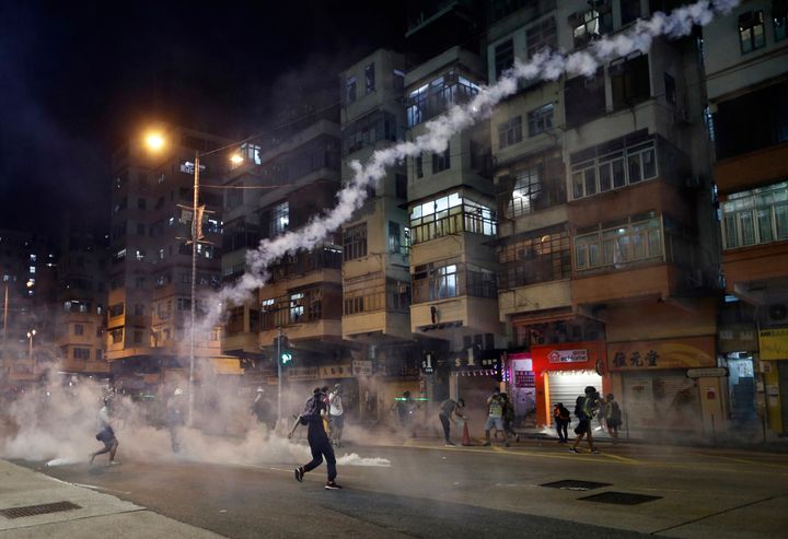 Protesters react to tear gas from Shum Shui Po police station in Hong Kong on Wednesday, Aug. 14, 2019. 