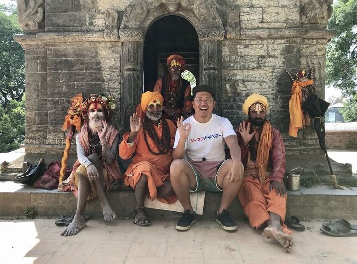 旅行で訪れたネパールの寺院で、地元の人たちと写真を撮る東松寛文さん（右から2人目）