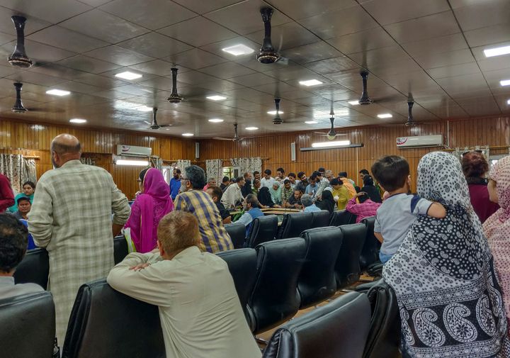 Kashmiris crowd around an official to use a phone at a government office, during restrictions after the scrapping of the special constitutional status for Kashmir by the government, in Srinagar August 10, 2019.