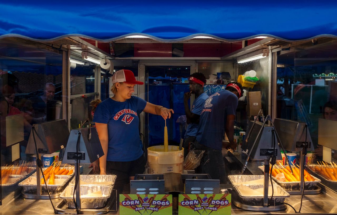 Employees of Campbell’s food stand prepare a corndog for the deep-fryer Sunday, Aug. 11, 2019. The Iowa State Fair is known for its corndogs and politicians.