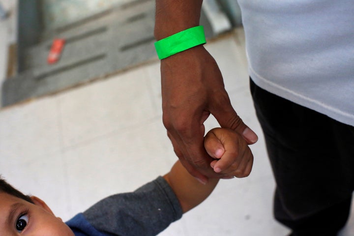 A child grabs the hand of his father at a Catholic shelter in Laredo, Texas, which gives temporary shelter to asylum-seekers