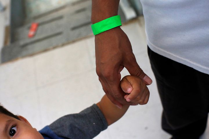 A child grabs the hand of his father at a Catholic shelter in Laredo, Texas, which gives temporary shelter to asylum-seekers from Central American countries released from detention due to overcrowded facilities, on June 4, 2019.