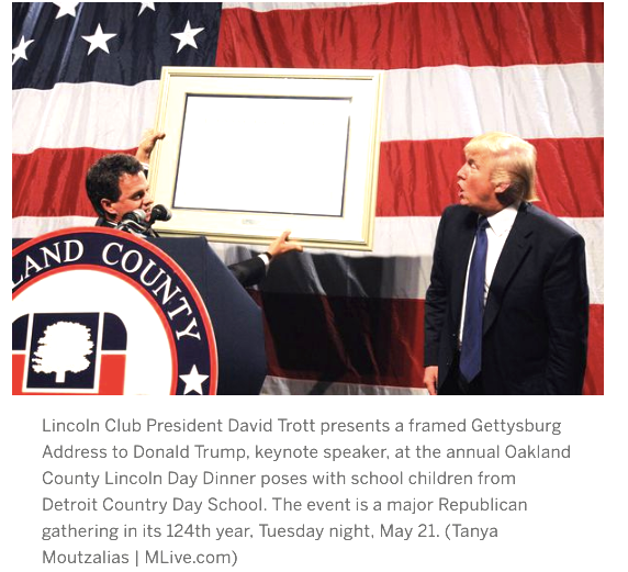 This is a screenshot of photo taken by MLive.com of the GOP Michigan dinner where Trump was given a framed copy of the Gettysburg Address, not a man of the year award.