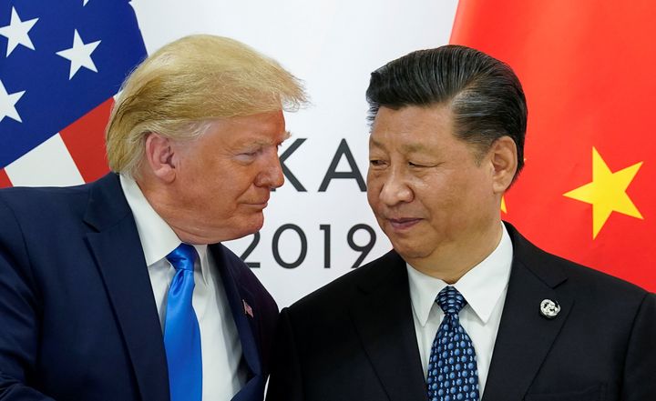 中国の習近平国家主席と握手を交わしながら顔を寄せるアメリカのトランプ大統領＝2019年6月29日、G20