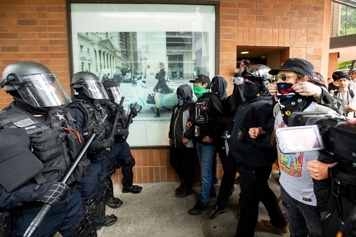 Police officers face off against protesters opposed to right-wing demonstrators following an "End Domestic Terrorism" rally in Portland, Ore., on Saturday, Aug. 17, 2019.