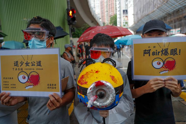 Protesters, wearing eye patches showing solidarity to a woman reportedly injured in the eye by a beanbag fired by police in a previous protest march, take part in a rally in Hong Kong on Sunday, Aug. 18, 2019.