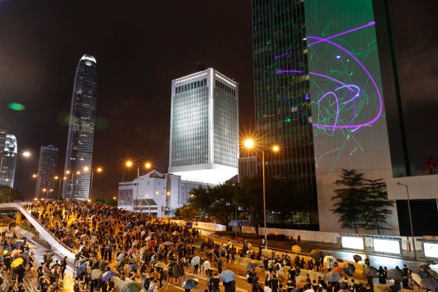 Protesters shine laser pointers on the Government Headquarters complex in Hong Kong, Sunday, Aug. 18,