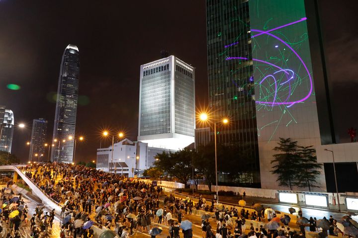 Protesters shine laser pointers on the Government Headquarters complex in Hong Kong, Sunday, Aug. 18, 2019. 