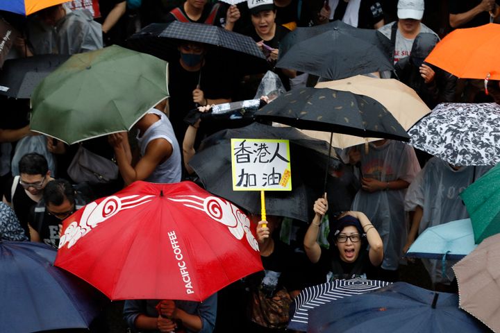 A participant reacts near a sign that reads: "Hong Kong people, Go!" during a protest rally in Hong Kong Sunday, Aug. 18, 2019.