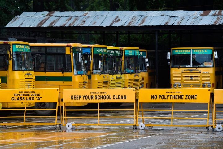 School buses are seen parked in the campus of a closed school in Srinagar on August 19, 2019. - 