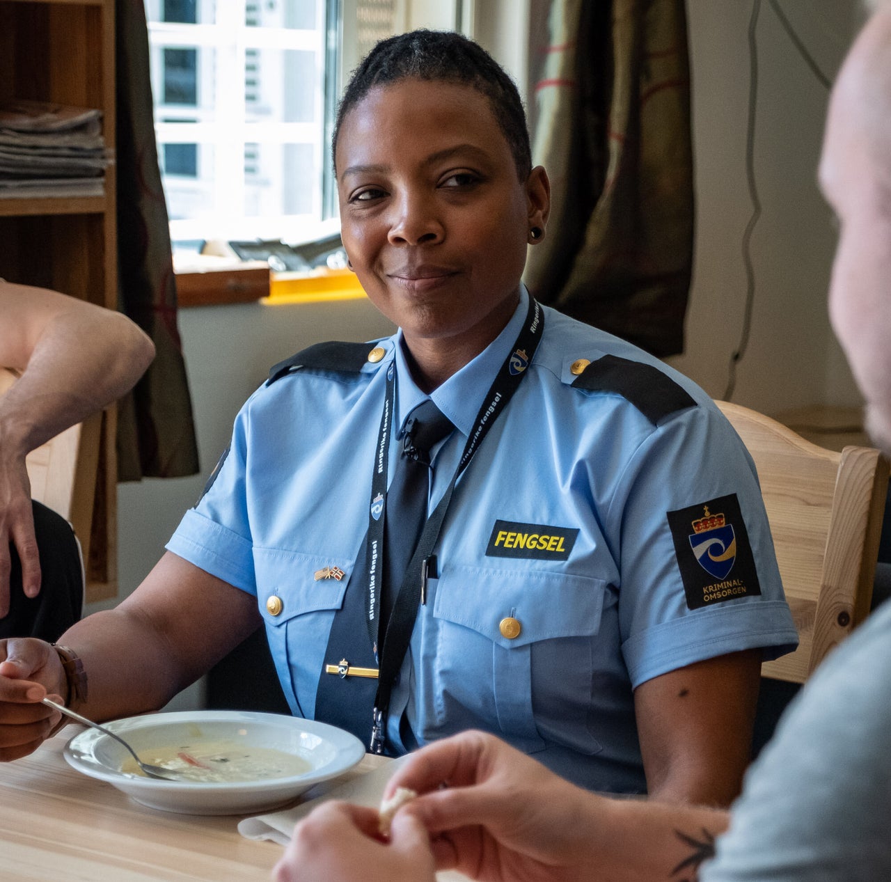 Turquoise Danford, an SCI Chester correctional officer, eating fish soup with a Ringerike inmate named Joakim.