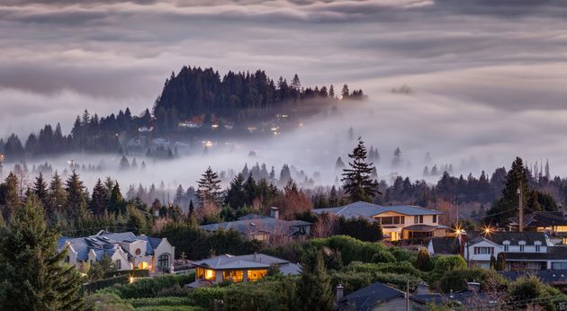 An aerial view of fog descending on homes in West