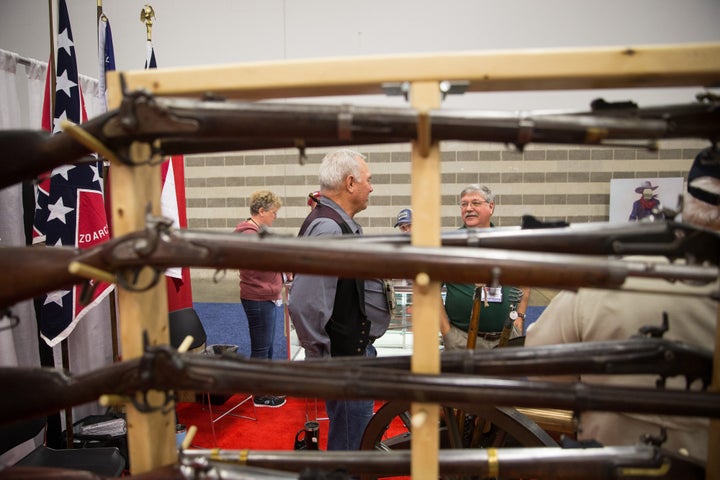 People browse firearms in an exhibit hall at the NRA's 2018 convention in Dallas, Texas.