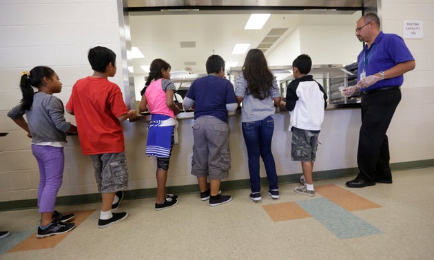 Detained immigrant children line up in the cafeteria at the Karnes County Residential Center, a detention...
