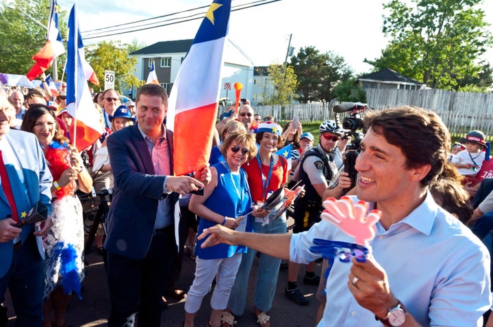 Prime Minister Justin Trudeau points to Conservative Leader Andrew Scheer while walking with the crowd during the Tintamarre in celebration of the National Acadian Day and World Acadian Congress in Dieppe, N.B. on Aug. 15, 2019.