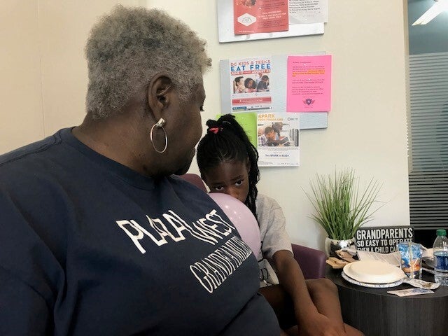 Cassandra Gentry, 67, sits with her nine-year-old granddaughter, Jada, at a back-to-school event at Plaza West, an affordable