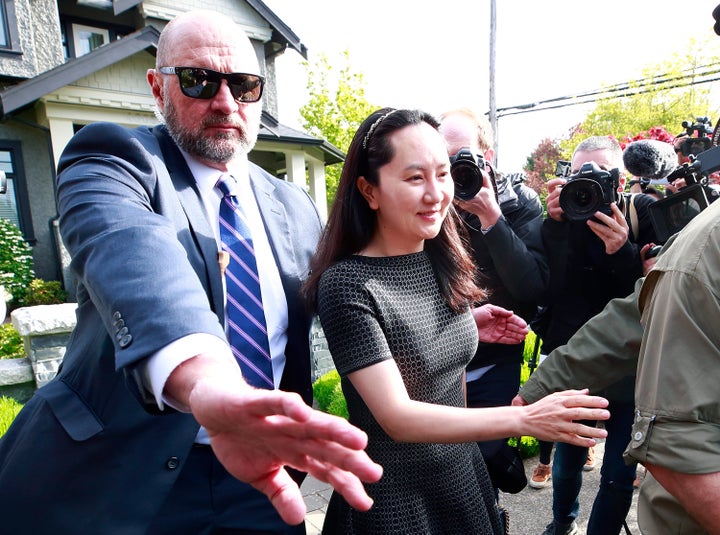 Huawei Technologies Chief Financial Officer Meng Wanzhou is escorted by security as she leaves her home on May 8, 2019 in Vancouver.