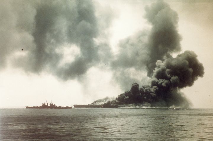 沖縄沖合で、旧日本軍の特攻隊の体当たり攻撃を受けて黒煙に包まれる米空母「バンカーヒル」（１９４５年５月１１日撮影）。アメリカ・ワシントンの米国立公文書館と海軍歴史センターで発見された約６００点の太平洋戦争当時の写真のうちの１枚［米国立公文書館提供］