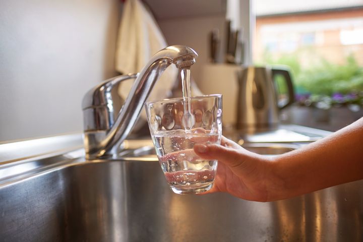 A woman fills her glass with fresh tap water.