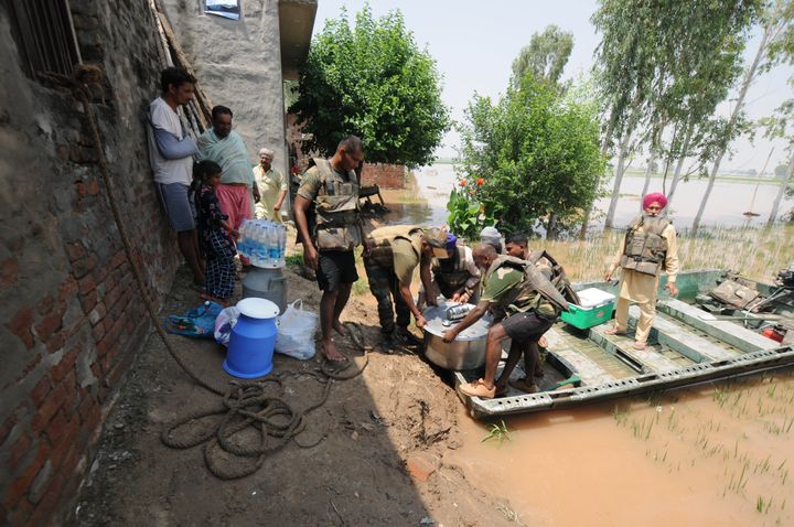 Army personnel carry food for villagers affected by severe floods, at Jamaliwala Village in Ferozpur district. 