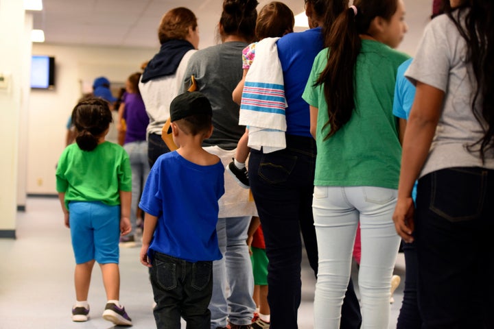 In this Aug. 9, 2018 photo provided by U.S. Immigration and Customs Enforcement, mothers and their children stand in line at South Texas Family Residential Center in Dilley, Texas. The family detention center is run as a for-profit business by CoreCivic, the country's largest private prison contractor.