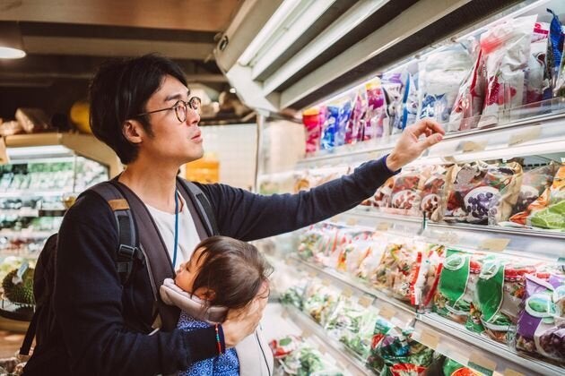 子供を抱っこしながら買い物をする父親 イメージ写真