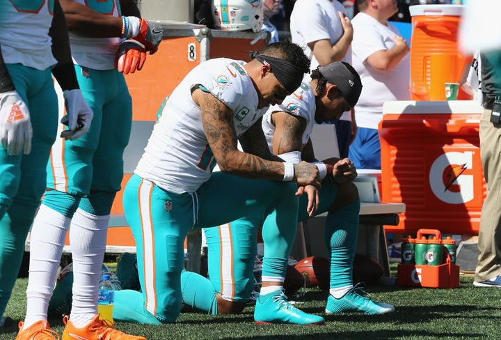 Kenny Stills and Albert Wilson of the Miami Dolphins kneel during the national anthem at Gillette Stadium in Foxborough, Mass