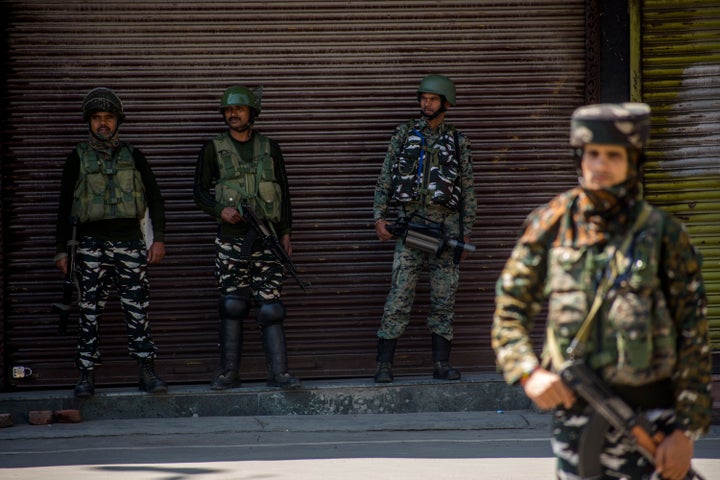 Indian paramilitary troopers stand guard in front the shuttered shops in Srinagar, the city centre, on Aug. 20, 2019.