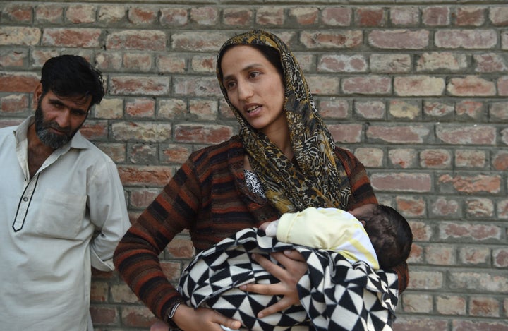 A Kashmiri mother waits outside a police station after her husband was detained during night raids in Srinagar on Aug. 20, 2019.