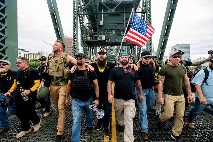 Members of the Proud Boys and other right-wing demonstrators march across the Hawthorne Bridge during a rally in Portland, Oregon, on Aug. 17, 2019. The group includes organizer Joe Biggs (in green hat) and Proud Boys Chairman Enrique Tarrio (holding megaphone).