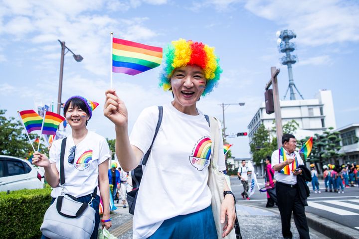 丸亀レインボーパレードで虹色の旗を振る参加者＝香川県丸亀市、2019年8月25日