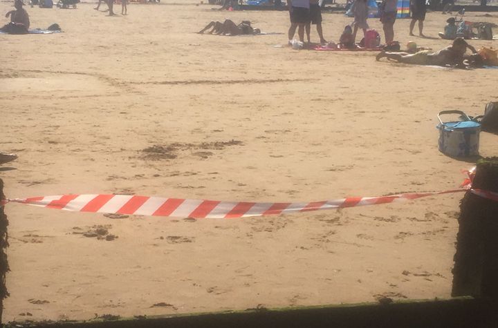 A warning tape is set at the beach in Frinton, Essex, as emergency services received several reports of people coughing and struggling to breathe.