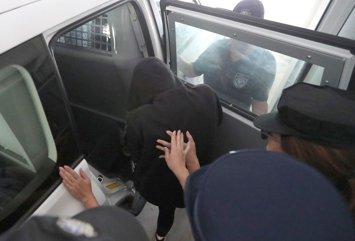 A 19-year old British woman enters a police vehicle with her head covered at the Famagusta court in Paralimni, Cyprus, on Tuesday 